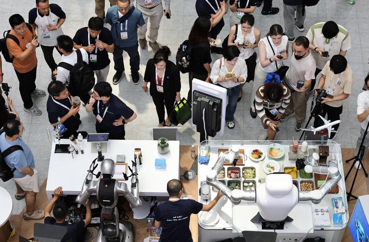 圖為7月17日，參觀者在世博展覽館內觀看機器人技能展示。新華社記者方喆 攝 